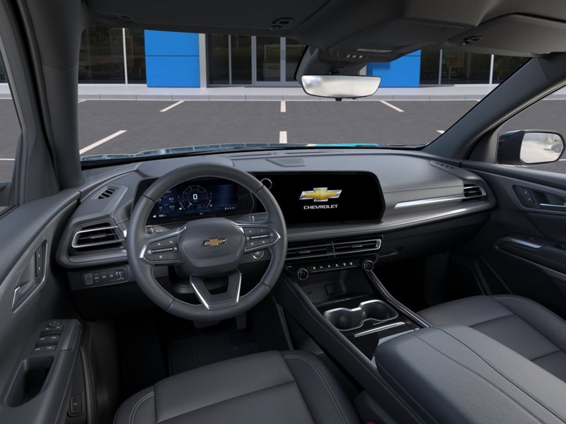 Habitacle moderne d’un Chevrolet Traverse avec volant multifonction, écran numérique central affichant le logo Chevrolet, console épurée et intérieur spacieux au design technologique et haut de gamme.